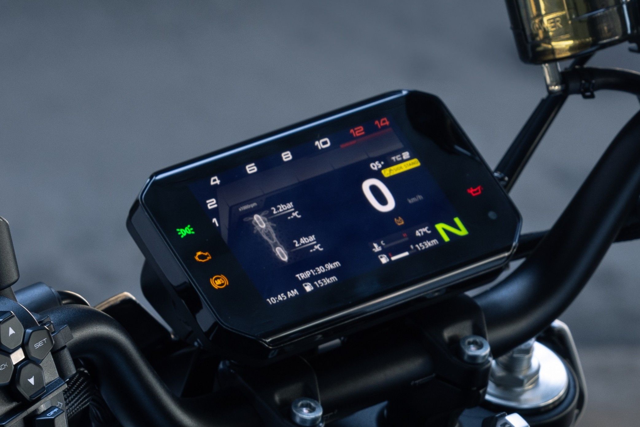 Landscape colour display, speed, neutral gear, tachometer, tyre-pressure readouts, temperature, fuel and left switchgear are visible.